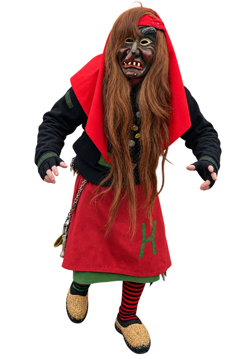Huzler Hexa im traditionellen Häs Huzler Hexa im traditionellen Häs mit Maske und langen rötlichen Haaren.